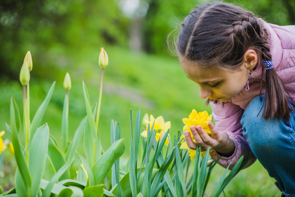 Niña oliendo una flor